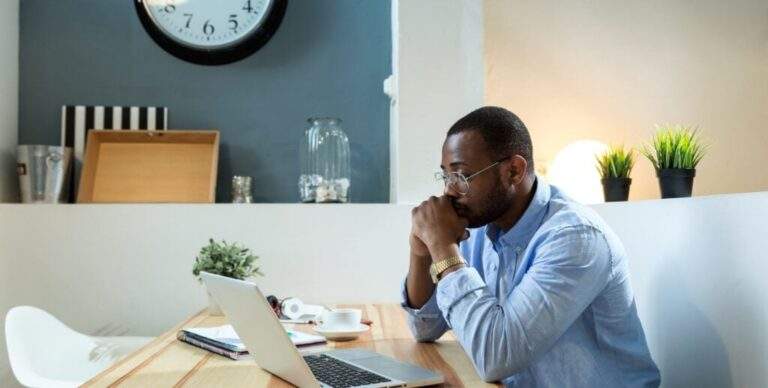 man thinking at laptop