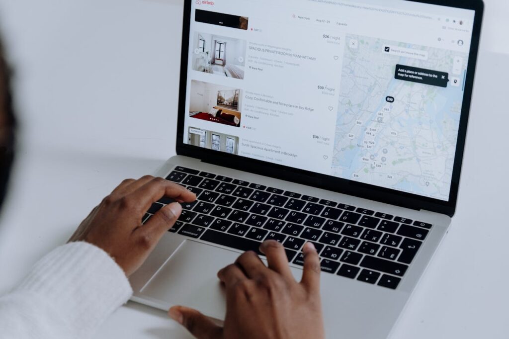 Gentrification vs. Revitalization: Where’s the Line, and What Does It Mean for Real Estate? 1 Woman using Airbnb on her computer.